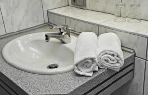 a bathroom sink with towels on a counter at Parkhotel "Am Schänzchen" in Andernach