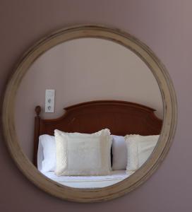 a mirror reflecting a bed with white pillows at Pension La Corredera in Tui