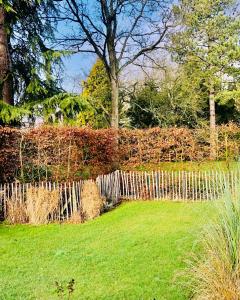 una valla de madera en un patio con césped verde en Vakantiehuis vlakbij het strand en natuur, en Biervliet