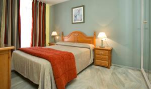 a bedroom with a bed with a red blanket at Ona Campanario in La Cala de Mijas