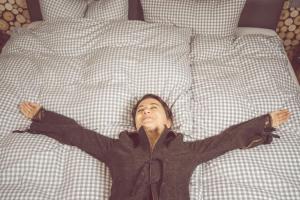 a young boy laying on a bed with his arms out at Landgasthof & Hotel beim Lipp in Roßhaupten