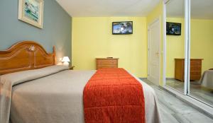 a bedroom with a large bed with a red blanket at Ona Campanario in La Cala de Mijas
