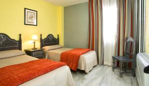 a hotel room with two beds and a window at Ona Campanario in La Cala de Mijas