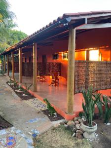 a house with a deck with a table and chairs at Club Manguaba Beira Rio in Japaratinga