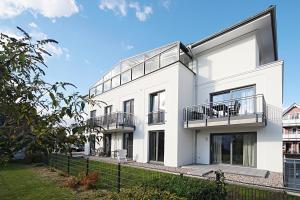 a white house with two balconies on it at Suite Salzluft mit Sauna in Zingst