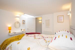 a white bedroom with a large white bed with red accents at Victoria Apartment 3 in Torquay