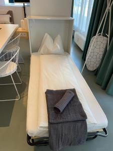 a hospital room with a bed with a towel on it at Main Station Design Loft Style Apartment in Innsbruck