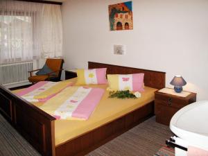 - une chambre dotée d'un grand lit avec des oreillers roses et jaunes dans l'établissement Apartment Elisabeth - ZAZ778 by Interhome, à Aschau
