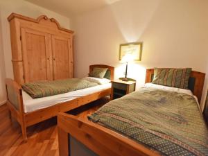 メラーノにあるApartment Villa Esperia by Interhomeのベッドルーム1室(ベッド2台、テーブルの上にランプ付)