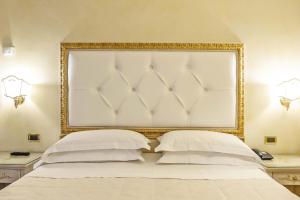 um quarto com uma cama branca com uma moldura dourada em Hotel Alba Palace em Florença