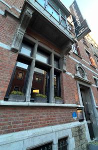 a window on a brick building with potted plants at Hotel Le Cygne d'Argent in Liège