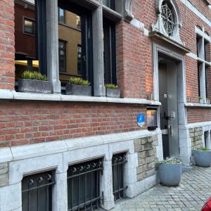 a brick building with windows and potted plants on it at Hotel Le Cygne d'Argent in Liège