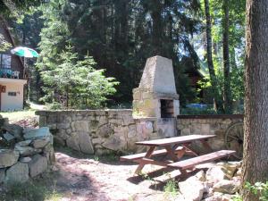 a wooden picnic table next to a stone wall at Chalet Bily - SZV100 by Interhome in Střížovice