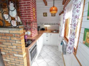 a kitchen with white cabinets and a brick wall at Chalet Bily - SZV100 by Interhome in Střížovice