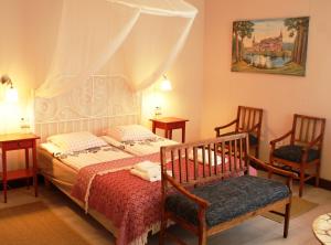 1 dormitorio con 1 cama y 2 sillas en Pokoje Przy Stoczku, en Białowieża