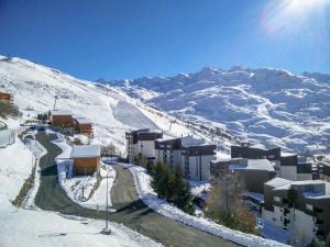 una montaña cubierta de nieve con edificios y una carretera en Apartment Le Médian-2 by Interhome, en Les Menuires