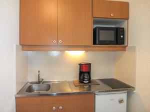 a kitchen with a sink and a microwave at Apartment Le Médian-2 by Interhome in Les Menuires
