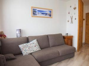 a living room with a couch and a picture on the wall at Apartment Le Médian-2 by Interhome in Les Menuires