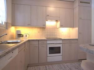 サンモリッツにあるアパートメント チェサ フローラ サンモリッツのキッチン(白いキャビネット、白い電化製品付)