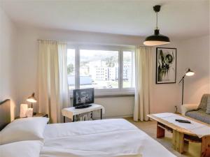 ein Hotelzimmer mit einem Bett und einem Fenster in der Unterkunft Apartment Chesa Ova Cotschna 303 by Interhome in St. Moritz