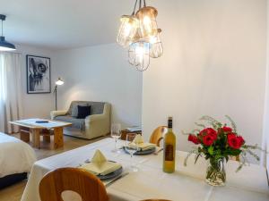 una sala de estar con una mesa de comedor con rosas. en Apartment Chesa Ova Cotschna 303 by Interhome, en St. Moritz