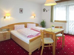 sypialnia z łóżkiem i małym stołem w obiekcie Apartment Beate by Interhome w Solden