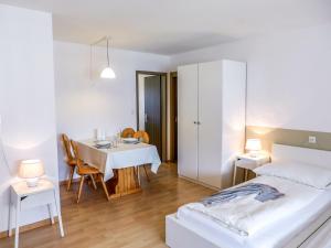 1 dormitorio con 1 cama, mesa y sillas en Apartment Chesa Ova Cotschna 304 by Interhome, en St. Moritz