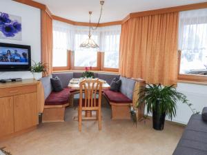 ein Wohnzimmer mit einem Tisch und Stühlen sowie einem TV in der Unterkunft Apartment Bergfeld - SIX171 by Interhome in Spiss