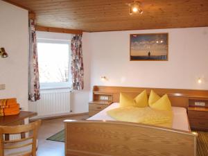 ein Schlafzimmer mit einem Bett mit gelben Kissen darauf in der Unterkunft Apartment Helga - TDL113 by Interhome in Tobadill