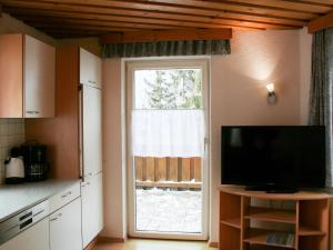 kuchnia z telewizorem i dużym oknem w obiekcie Apartment Helga-2 by Interhome w mieście Tobadill