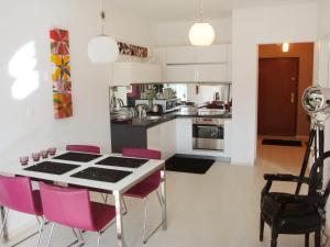 ビェルスコ・ビャワにあるApartment Apartament Olszówka by Interhomeのキッチン(テーブル、ピンクの椅子付)