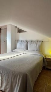 アチレアーレにあるCasa Via Vigoの大型ベッド(白いシーツ、枕付)