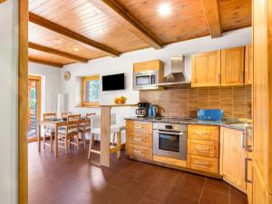 a kitchen with wooden cabinets and a dining room at Holiday Home Bila Retreat with Pool by Interhome in Blažejov