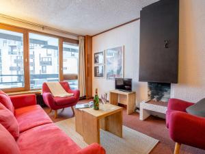 a living room with red furniture and a fireplace at Apartment Le Grand Tichot A et B - Val Claret-12 by Interhome in Tignes