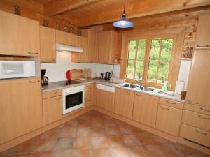 una cucina con armadi in legno e un apparecchio bianco di Holiday Home Haus Fries by Interhome a Unterbergern