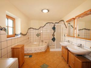 łazienka z wanną, 2 umywalkami i wanną w obiekcie Holiday Home Haus Fries by Interhome w mieście Unterbergern