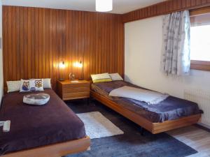 2 letti in una camera con pareti rivestite in legno di Apartment Val Neige 11 by Interhome a Verbier
