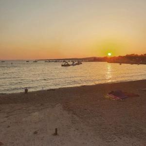 una puesta de sol en una playa con barcos en el agua en Apartmani Mujic, en Vir