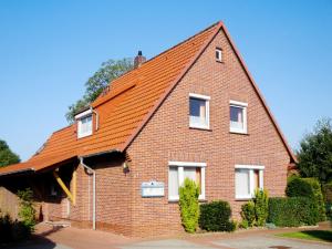 ブルハーフェにあるHoliday Home Fischerhaus by Interhomeの大煉瓦造りのオレンジ色の屋根の家