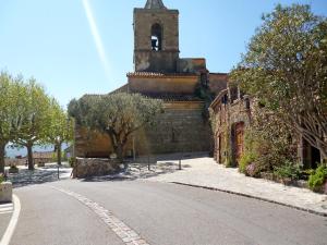 un antiguo edificio con una torre de reloj en una calle en Holiday Home Maury by Interhome en Grimaud