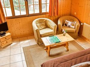 ein Wohnzimmer mit 2 Stühlen und einem Couchtisch in der Unterkunft Apartment Rousserolles rez gauche by Interhome in Verbier