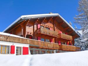 un grand bâtiment en bois avec un balcon dans la neige dans l'établissement Apartment Rousserolles 4 by Interhome, à Verbier