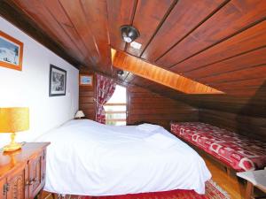 ヴェルビエにあるApartment Mirador 186 by Interhomeの白いベッドと木製の天井が備わるベッドルーム1室が備わります。