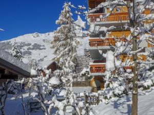 a building covered in snow with a snow covered tree at Apartment Talisman 7 by Interhome in Verbier