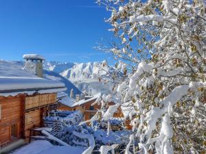 a tree covered in snow next to a building at Apartment Boule de Neige by Interhome in Verbier