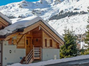 een huis met sneeuw op het dak met een berg bij Apartment Boule de Neige by Interhome in Verbier
