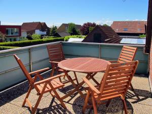 d'une table en bois et de deux chaises sur un balcon. dans l'établissement Apartment Kipping by Interhome, à Schillig