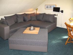 ein Wohnzimmer mit einem Sofa und einem Tisch in der Unterkunft Apartment Alte Molkerei-2 by Interhome in Friederikensiel
