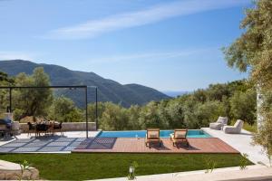 a backyard with a pool and a table and chairs at High-end Villa Faos Three in Fternón