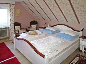 a bedroom with a large bed with two chairs at Holiday Home Lilly by Interhome in Osteel